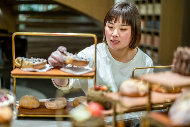 istock Young Asian female baker is working in the bakery 1282307353