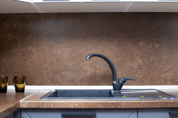 istock Kitchen interior, countertop with built-in sink made of black artificial stone 1282311586