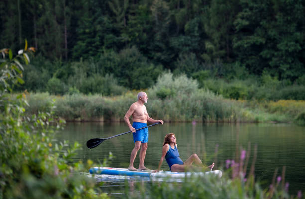 istock Senior couple paddleboarding on lake in summer. 1282312960