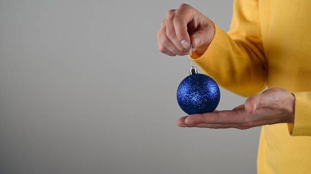 青いクリスマスボールを手に持っている男 - christmas ball christmas ornament human hand ストックフォトと画像