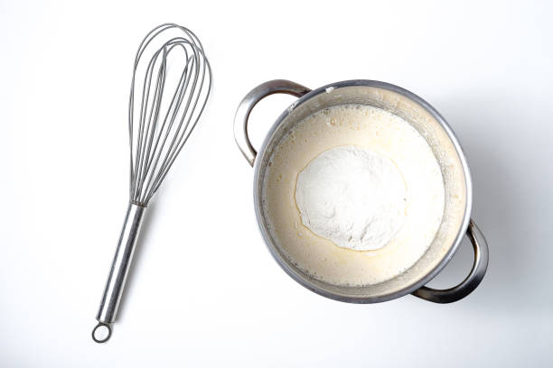 istock saucepan with dough and whisk on a white background. 1282315029