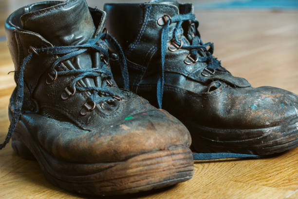 istock Old worn-out workman's shoes. Shoes that require repair or replacement 1282316164