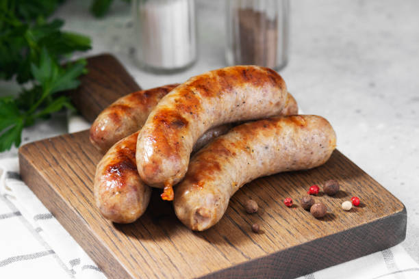 istock Grilled sausages on a wooden Board on a light gray kitchen table 1282316389