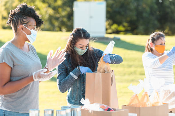 istock Three women work together to sort food into bags 1282319889