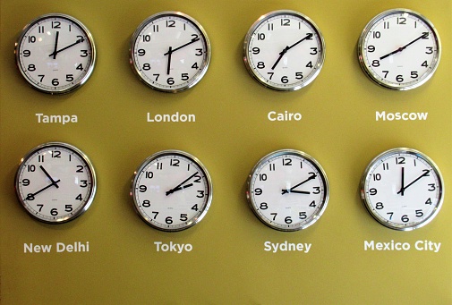 Set of wall clocks showing the time in different places in the world.