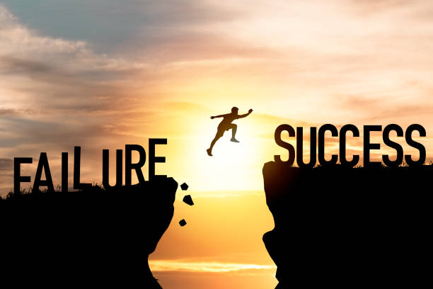 istock Mindset concept ,Silhouette man jumping from failure to success  wording on cliff with cloud sky and sunlight. 1282320042