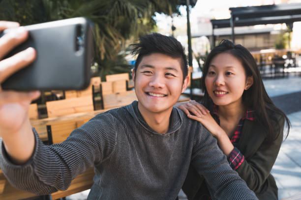 istock Asian couple taking a selfie with mobile phone. 1282320502