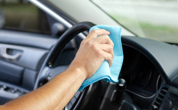istock Cleansing car interior and wheel. Male hand  disinfecting vihicle inside 1282321556