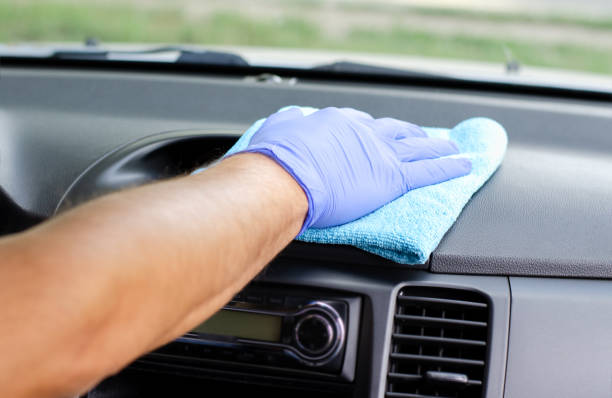 istock Cleansing car interior. Male hand  in protective glove disinfecting vihicle inside 1282321557