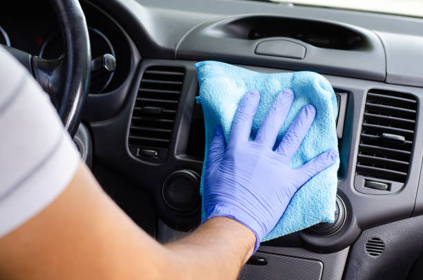 istock Cleansing car interior. Male hand  in protective glove disinfecting vihicle inside 1282321643