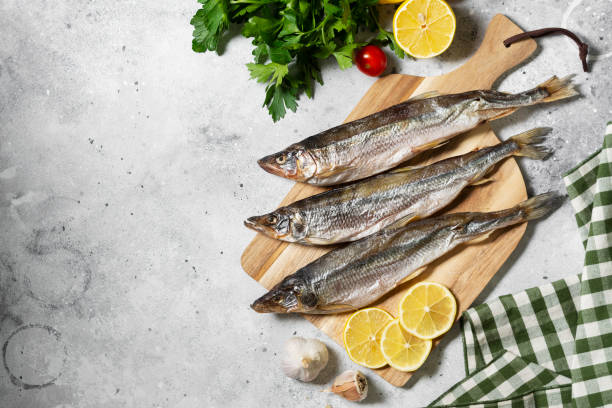 istock Smoked or dried fish smelt on a wooden Board on a gray kitchen table 1282324029