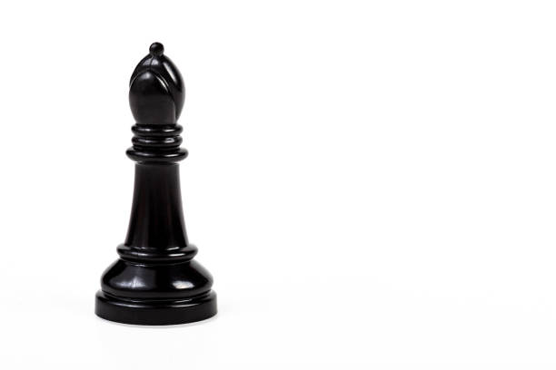istock Simple one single shiny black bishop chess piece figure alone, isolated on white background, object cut out, big game piece chess set element, simplicity, closeup, copy space on right side 1282325036