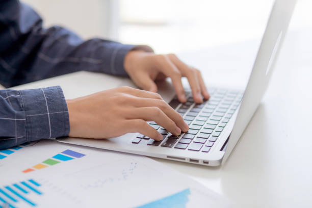 istock Hand of business man typing keyboard on laptop while document data graph and chart, marketing and investment, report of statistics profit for financial, growth of finance, management and planning. 1282326597