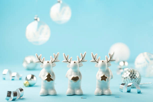 istock Christmas card with small glass white deer, silver decorations, mirror disco balls on light blue background. 1282327422