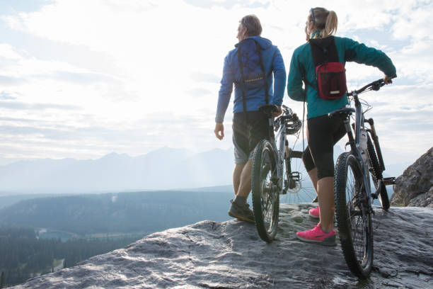 istock Father and daughter walk out to mountain ledge with bicycles 1282327931