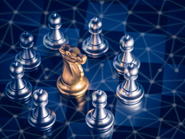 istock Golden knight chess is surrounded by around silver chess pieces on chess board with network and communication to fighting with teamwork to victory, business strategy concept for success. 1282328236