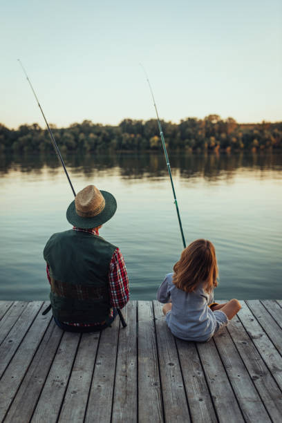 esses peixes não têm chance. - fishing lake grandfather grandson - fotografias e filmes do acervo