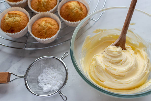 glaçage à la crème au beurre pour décorer les petits gâteaux - crème au beurre photos et images de collection