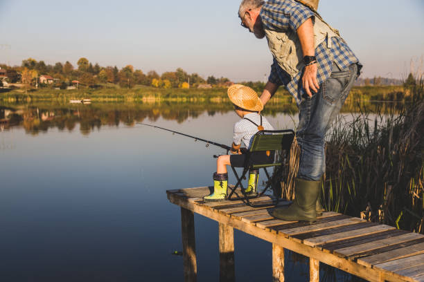 istock Senior man fishing with grandson 1282331320