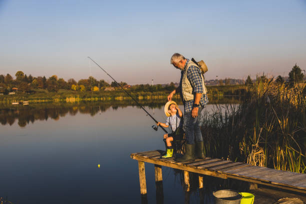 istock Senior man fishing with grandson 1282331435