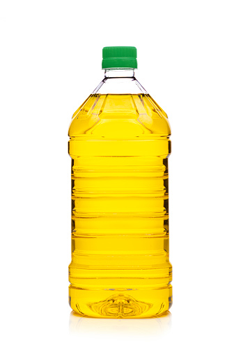 Front view of a 2 liters plastic cooking oil bottle isolated on white background. A green cap is at the top of the bottle. Predominant colors are yellow and white. High resolution 42Mp studio digital capture taken with Sony A7rII and Sony FE 90mm f2.8 macro G OSS lens