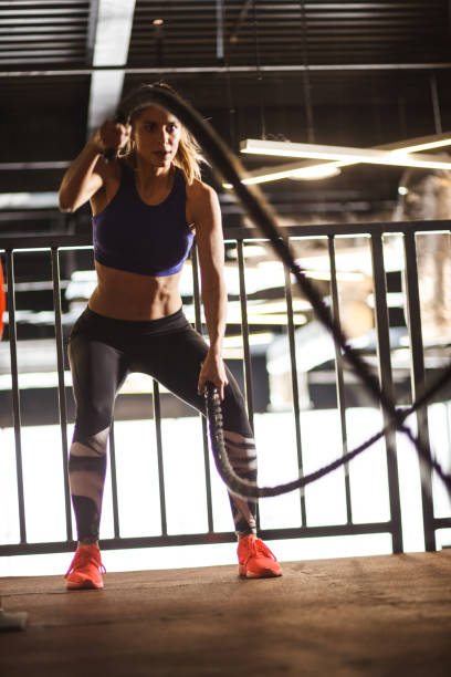 istock Female athlete doing a full body workout using battle ropes 1282332160