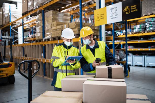 istock Workers with face mask working indoors in warehouse, coronavirus concept. 1282332931
