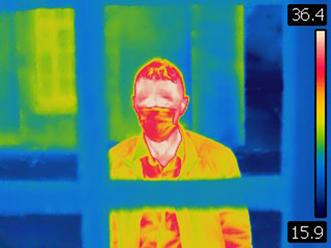 Image is taken with Flir T420 infra red camera. Each color represents different temperatures, as is shown on spectrum scale on right side of image. Covid19 coronavirus spreads around the world causing global pandemic.