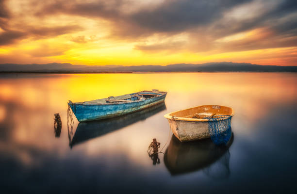 Amazing sunset in Delta del Ebro with two boats floating in the sea