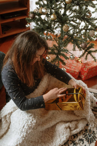 istock Young woman opening christmas presents 1282340328