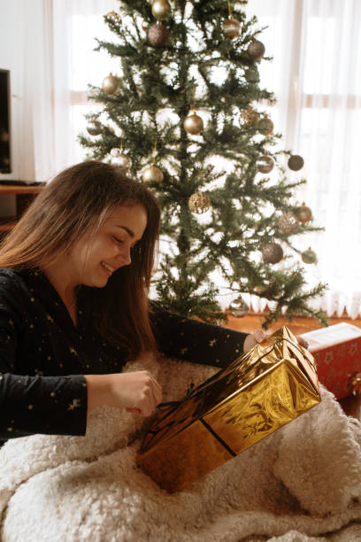 istock Young woman opening christmas presents 1282340348