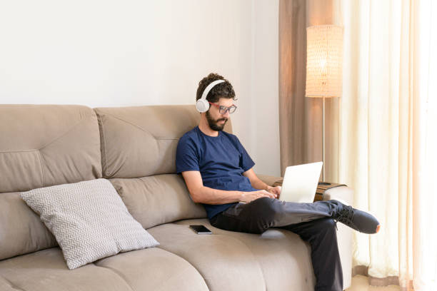 istock Young man working at home sitting on the sofa. 1282340859