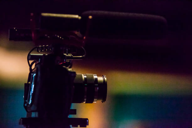 istock Camera taking live video streaming at event over dark colorful background 1282341816