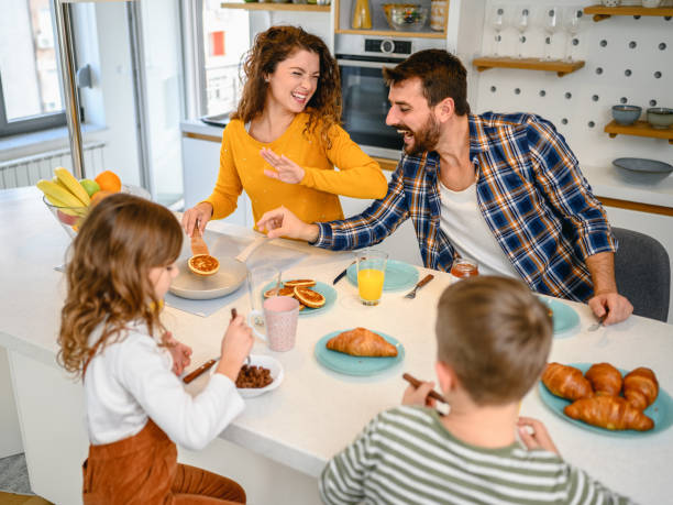 istock Young happy family communicating while having breakfast in the kitchen 1282341850