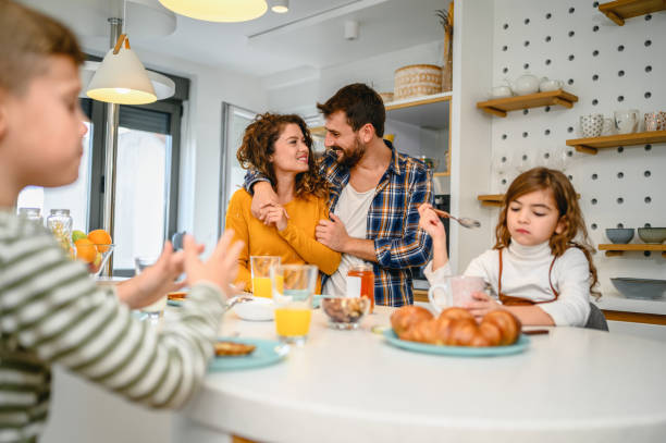 istock Young happy family communicating while having breakfast in the kitchen 1282343118