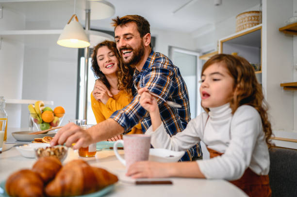 istock Young happy family communicating while having breakfast in the kitchen 1282343333