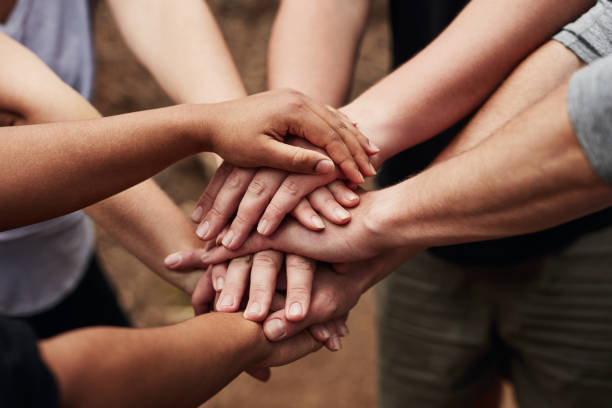 Solidarity is at the heart of humanity Cropped shot of a group of unrecognisable people joining hands in solidarity out in nature racial equality stock pictures, royalty-free photos & images