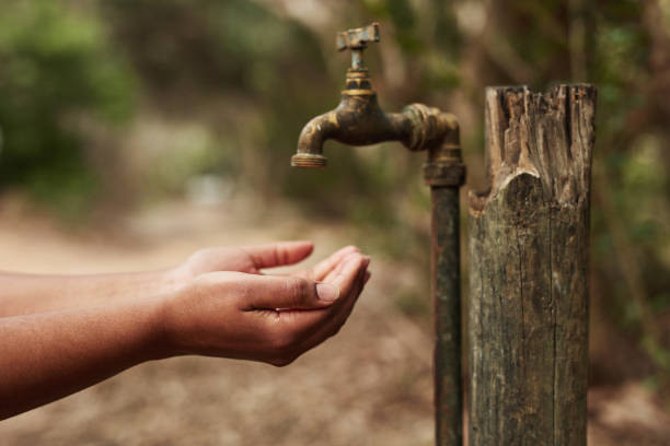We’ve never needed water more than we need it now Cropped shot of an unrecognisable woman holding her hands out for water from a tap in nature water crisis stock pictures, royalty-free photos & images