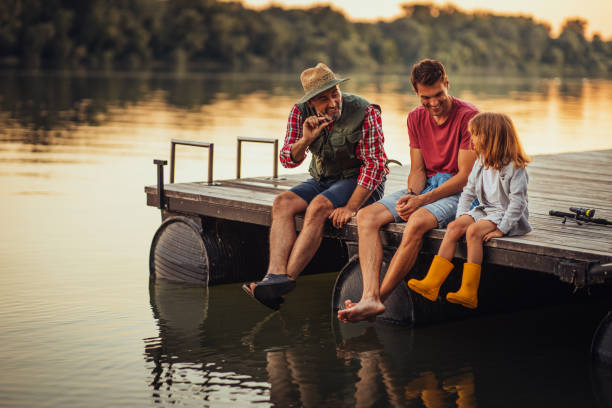 reel dans le plaisir et le bonheur - fishing lake grandfather grandson photos et images de collection