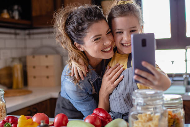 istock Mother and daughter having fun and preparing lunch in the kitchen 1282344856