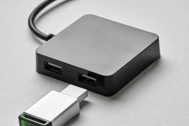 istock Black portable USB hub for four connections with usb flash drive on a white background. Bus povered. Closeup, selective focus 1282345372