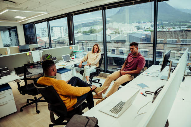 istock Diverse small group of colleagues relaxing during lunch break discussing weekend plans in office 1282346515