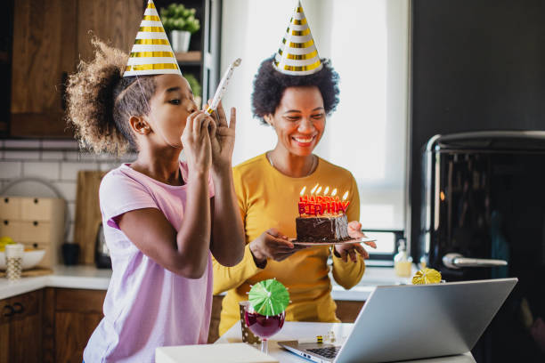 Mother and daughter having online birthday celebration at home African American mother and daughter are celebrating birthday via video call virtual birthday celebration stock pictures, royalty-free photos & images