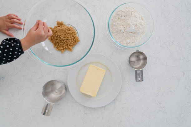 istock cookie ingredients on counter and child's hand reaching in 1282348264