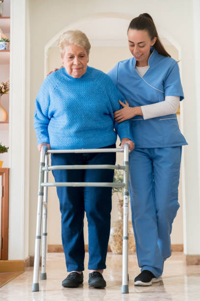 istock Nurse helping a senior woman walking with a mobility walker 1282348281