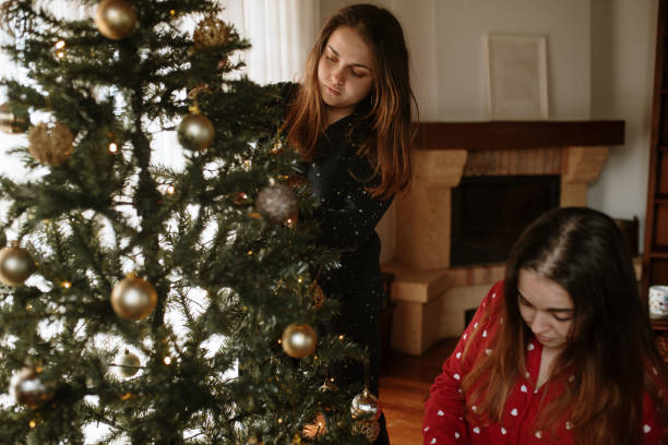 istock Young twin sisters decorating a christmas tree 1282348386