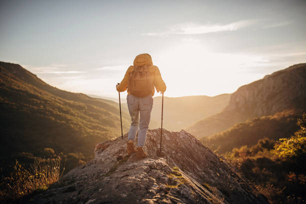 istock Young woman with backpack hiking in the mountains 1282348546