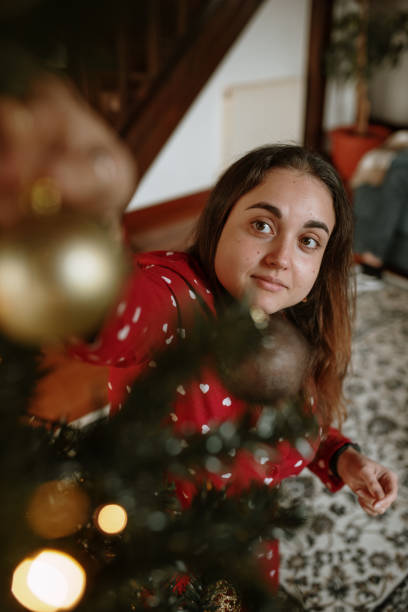 istock Young woman decorating a christmas tree 1282348712