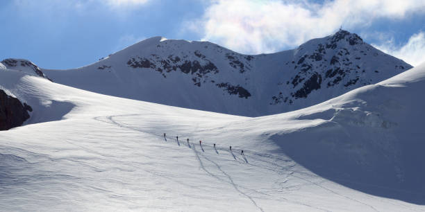 zespół linowy alpinista z raków na lodowcu taschachferner w kierunku wildspitze i górskiej panoramy śniegu z błękitnym niebem w tyrolskich alpach, austria - oetztal alps zdjęcia i obrazy z banku zdjęć