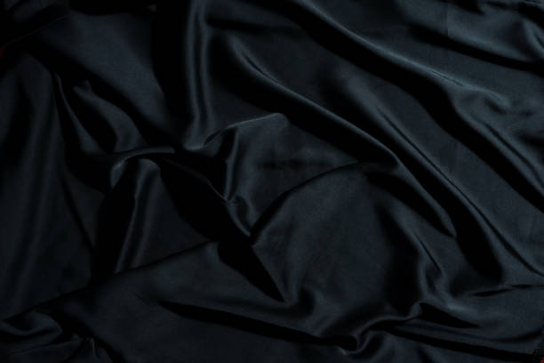 istock Crumpled textile fabric background of black color. 1282350024